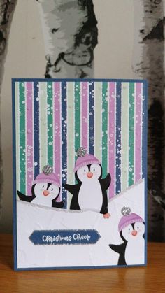 a christmas card with two penguins wearing hats