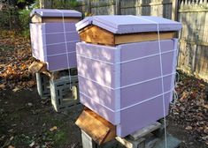 two purple beehives sitting next to each other