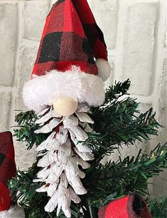 a red and black plaid christmas tree with santa claus hat on it's head