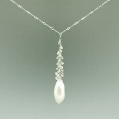 One of a kindHandmade in Seattle Unique long oval baroque pearl with smaller white and pale grey pearls on polished silver chain Materials: solid sterling silver fresh water pearls Measurements: Adjustable necklace chain: 17" - 19" Pendant area: 2 5/8" long x 3/8" wide Comfortable - Adjustable length fits varying necklines and light weight makes it easy to wear Timeless - pearls never go out of style High Quality - all chain connections are welded and pearls/gems are tightly wire wrapped, custom White Pearl Necklace With Silver Chain, Sterling Silver Lariat Pearl Necklace, Sterling Silver Lariat Pearl Necklace With Pendant, Silver Oval Pearl Drop Necklace, Silver Oval Necklace With Pearl Drop, Silver Pearl Necklace With Drop Shape, Silver Long Drop Necklace With Pearl, Sterling Silver Oval Pearl Drop Necklace, Sterling Silver Briolette Pearl Pendant Necklace