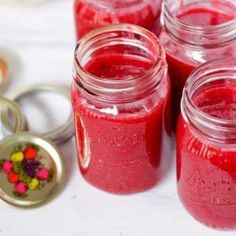 several jars filled with red liquid next to a keychain