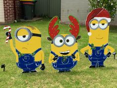 three cartoon characters are standing in the grass with one wearing a santa hat and two wearing blue overalls