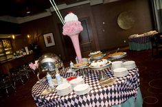 a table topped with plates and bowls filled with desserts next to a vase full of flowers