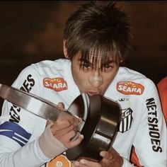 a young man holding a metal object in his hands