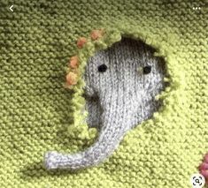 an elephant crocheted blanket with flowers in the middle and a hole at the bottom