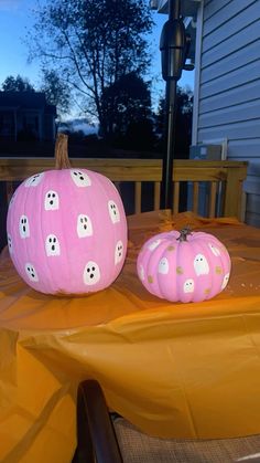 two pink pumpkins sitting on top of a table