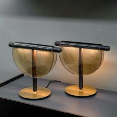 two lamps sitting on top of a black table