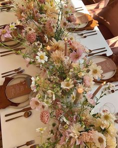 an arrangement of flowers on a long table