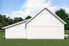 a large white barn sitting on top of a lush green field