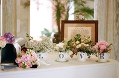 the bride and groom are posing for pictures in their wedding gowns, with floral arrangements