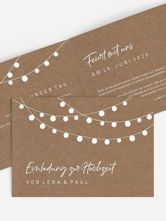 two brown and white wedding cards with string lights on the front, one is for each guest