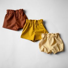 three different colored shorts on a white background