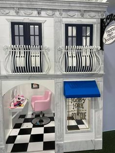 an image of a doll house with furniture and accessories in the front porch window area