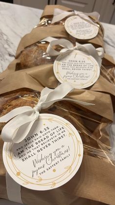 bread wrapped in brown paper and tied with white ribbon on top of a marble counter