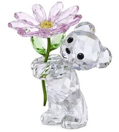 a crystal bear holding a flower in its paws