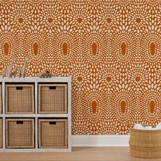 an orange and white wallpaper with flowers in the center is next to a basket