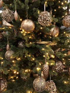 the christmas tree is decorated with gold and silver ornaments