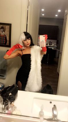 a woman taking a selfie in front of a bathroom mirror with her cell phone