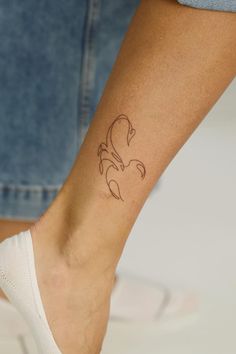 a woman's foot with a tattoo on her left ankle and the bottom part of her leg