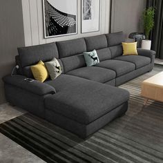 a living room with gray couches and yellow pillows on the floor next to a coffee table