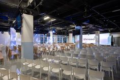 an empty room with rows of white chairs