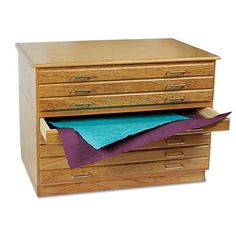 a wooden file cabinet with blue paper on top