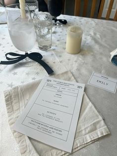 a table with napkins, candles and glasses on it in front of the menu