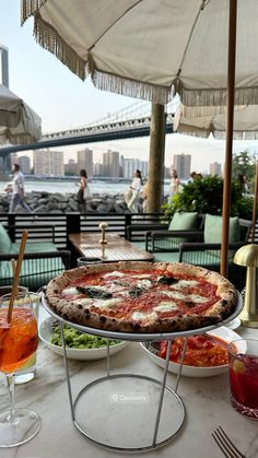 a pizza sitting on top of a table next to drinks