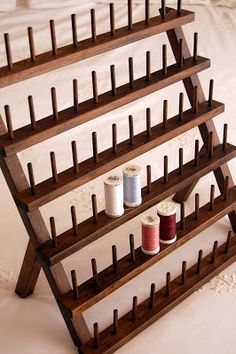 a wooden rack holding several spools of thread