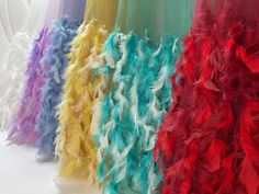 there are many different colors of feathers on the dress mannequins in this photo