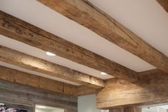 a living room filled with furniture and wooden beams