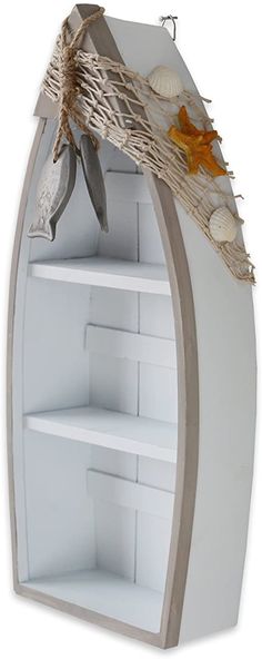 a white boat shaped shelf with seashells on it's sides and an orange ribbon hanging from the top