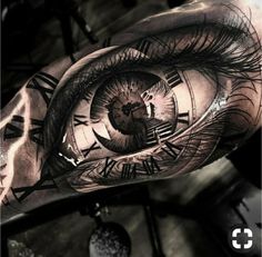 an eye tattoo on the arm with roman numerals and clock faces in it