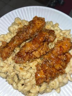 a white plate topped with macaroni and cheese covered meat