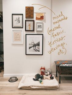 a dog bed in the middle of a room with pictures on the wall