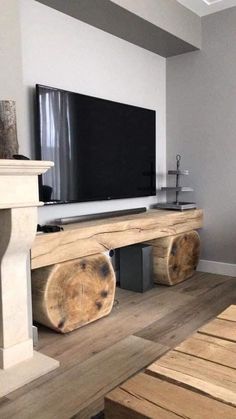 a living room with wooden furniture and a flat screen tv mounted on the wall above it