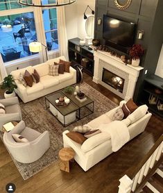 a living room filled with furniture and a flat screen tv mounted to a wall above a fire place