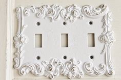 an ornate white light switch plate cover