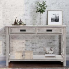 a white wooden table with two drawers and some pictures on the wall next to it