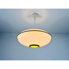 a white ceiling light hanging from the ceiling in a room with blue walls and flooring