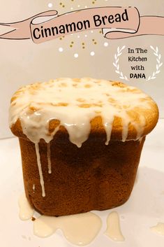 a close up of a cake with icing on a white tablecloth and an advertisement for cinnamon bread in the background