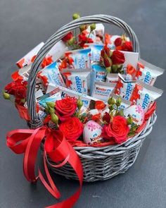 a basket filled with candy and roses on top of a table