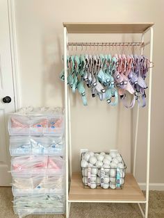 an organized closet with baby shoes and diapers hanging on the clothes rack next to it