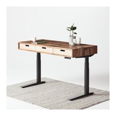 a wooden desk with two drawers on one side and a plant on the other end