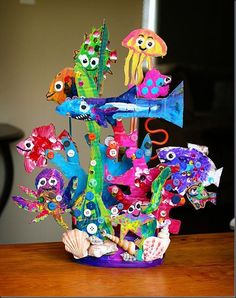 an arrangement of fish and sea creatures in a vase on a table with other items