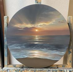 a painting of the sun setting over the ocean