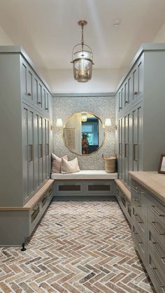 a long hallway with many drawers and a large mirror on the wall above it's doors