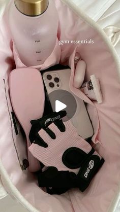 the contents of a woman's personal care product arranged in a pink basket on a bed