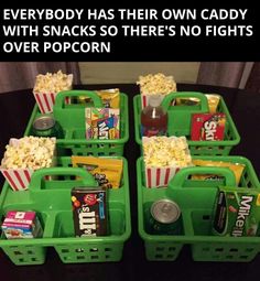 four green baskets filled with movie snacks and sodas on top of a black table