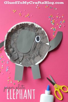 paper plate elephant craft with scissors and sprinkles on pink background for kids to make